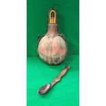 An African tribal carved wooden spoon and a leather mounted gourd shaped water vessel