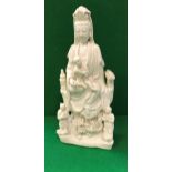 An 18th Century Chinese blanc-de-chine figure of Guan Yin with child upon her knee,