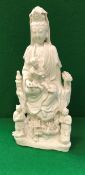 An 18th Century Chinese blanc-de-chine figure of Guan Yin with child upon her knee,
