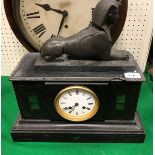 A black marble mantel clock together with a model of a sphinx and a basket of assorted stone and
