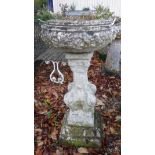 A natural stone planter on ornate pedestal to egg and dart decorated plinth
