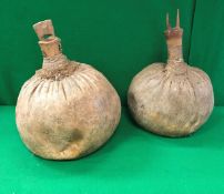 Two tribal gourd shaped water carriers with wooden stoppers, one decorated with a pair of horns,