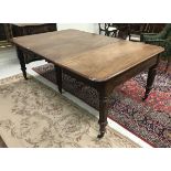 An early Victorian mahogany extending dining table the rounded rectangular top with extra leaves
