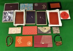 A collection of Japanese silk fukusa and small cases, some with wooden trays,