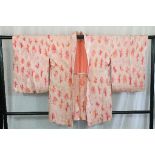 A circa 1970 silk haori (jacket) with So-Shibori (tie-dyed) pink decoration on orange ground