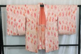 A circa 1970 silk haori (jacket) with So-Shibori (tie-dyed) pink decoration on orange ground