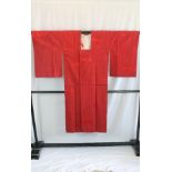 A circa 1970 silk rain coat with Take (bamboo) decoration on a red ground