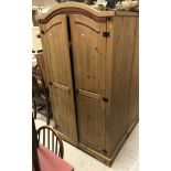 A pair of modern pine wardrobes, a pair of matching pine three drawer bedside chests,