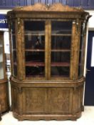 A circa 1850 bow ended walnut display cabinet in the French taste with blind doors to base and