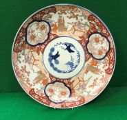 A 19th Century Japanese Imari charger decorated with panels of figures in garden settings and