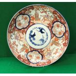 A 19th Century Japanese Imari charger decorated with panels of figures in garden settings and