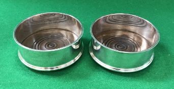 A pair of modern silver mounted bottle coasters with turned wooden bases (by John and Maureen