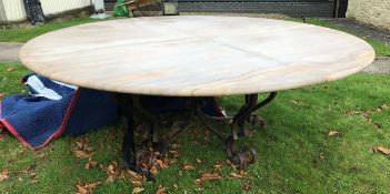 A wrought iron based marble top garden table