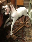 A vintage painted wooden rocking horse of small proportions,