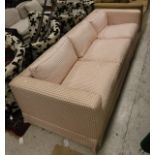 A modern three seater sofa with cream and red check upholstery