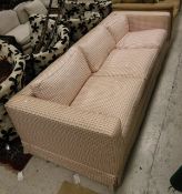 A modern three seater sofa with cream and red check upholstery