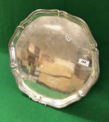 An Edwardian silver salver with pie-crust rim,