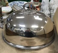 A large oval plated food dome with beaded decoration to the handle and rim