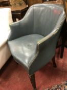 A circa 1900 blue leather upholstered and studded tub chair with square tapering front legs to