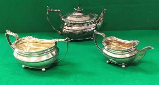 A late George III silver three piece tea set of rounded rectangular form, raised on four ball feet,