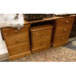 A modern pine knee hole dressing table and three pine bedside chests