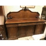 A Victorian mahogany sideboard with raised back over drawers and cupboard door
