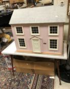 A modern Victorian style dolls house and stand together with box of various furniture and