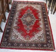 A Persian rug, the central panel set with foliate decorated medallion on a red ground,