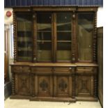 A Victorian oak breakfront bookcase with half carved Gothic style decoration CONDITION