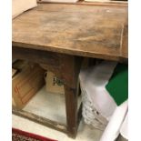 A French oak farmhouse kitchen table with plank top above a plain frieze on supports united by