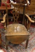 A 19th Century oak commode armchair in the Provincial Chippendale taste and a 19th Century mahogany