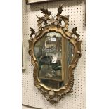 An 18th Century shaped giltwood framed wall mirror with scrolling acanthus decoration