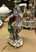 A 19th Century Continental porcelain figure of a gentleman in gilt decorated costume with dog at