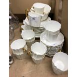 A Wedgwood part tea service with plain white ground and gilt decorated handles,
