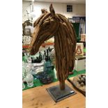 A modern drift wood sculpture of a horse's head,
