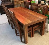 A modern Indian teak dining table and set of eight slat back dining chairs