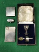 A silver Christening set of egg cup, napkin ring and spoon, sovereign case and two cigarette cases,