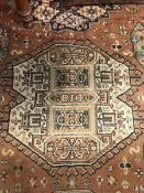 A Persian style rug, the central panel set with geometric medallions on a brown ground,