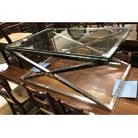 A modern Eichholtz glass topped and chrome x-framed coffee table