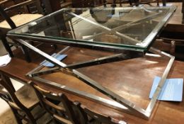 A modern Eichholtz glass topped and chrome x-framed coffee table