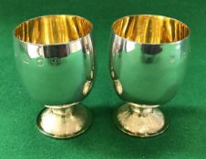 A pair of modern silver goblets with gilt-washed interiors and textured circular feet (by Hugh