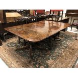 A late George III mahogany twin pillar dining table with two rounded rectangular end sections and