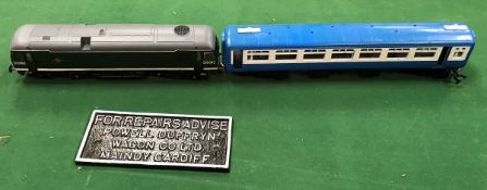 An unnamed O gauge British Railways diesel loco together with two unnamed carriages and a cast iron