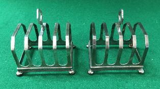 A pair of George V silver four section toast racks with pierced galleried bases,