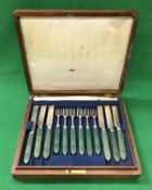 A set of twelve George IV silver and green stained ivory handled fruit knives and forks (by Aaron