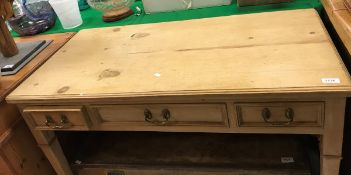 A Victorian pine side table with three drawers on square tapering legs to brass castors