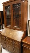 A 19th Century mahogany bureau bookcase with glazed upper section over a sloping fall and two short