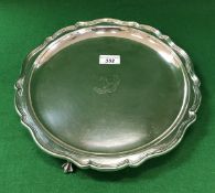 An Edwardian silver salver with pie-crust rim, raised on three claw and ball feet,