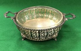 A George V pierced silver dish of ogee form with two open scrollwork decorated handles,