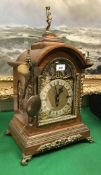 An early 20th century oak cased mantle clock with gilt brass embellishments,